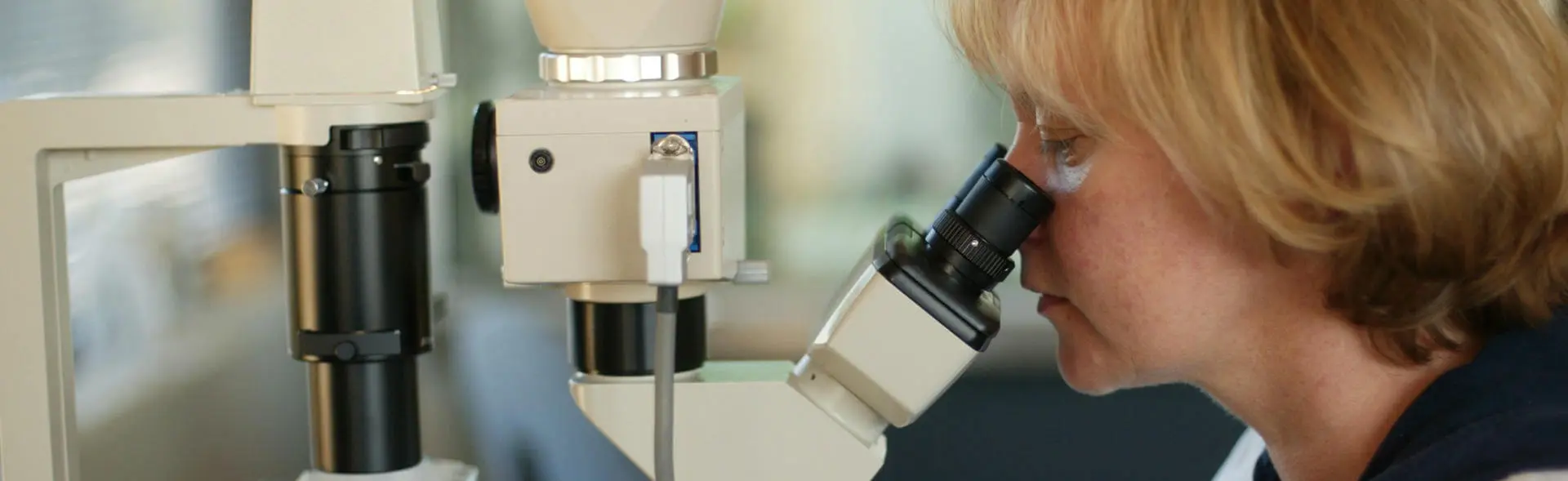 Researcher looking through a microscope 